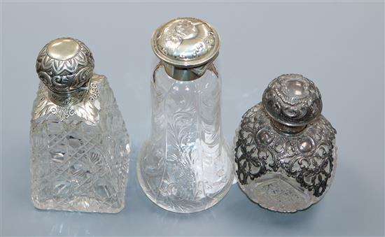 Three assorted Edwardian repousse silver mounted cut glass scent bottles, including Reynolds Angels by William Comyns,